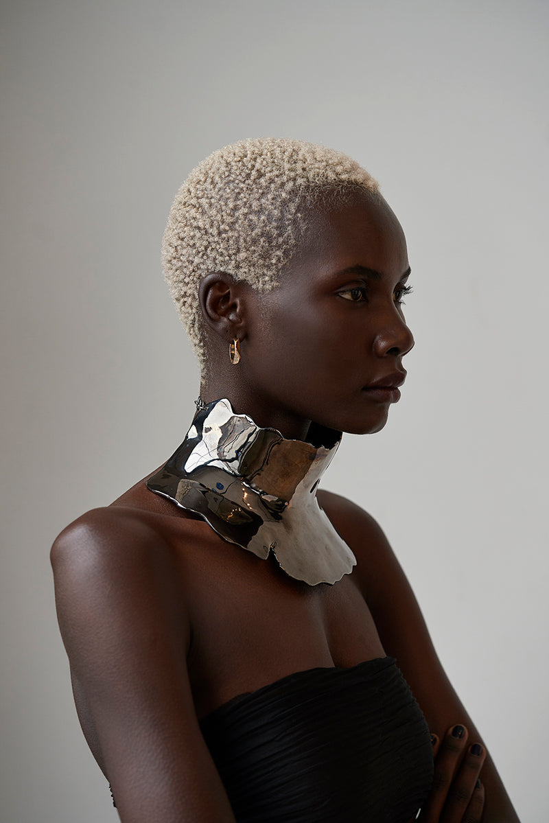 Tricia wearing Sterling King Magma Sculpted Neckpiece in Black Rhodium paired with Lithop Ridge Mini Hoops in Gold